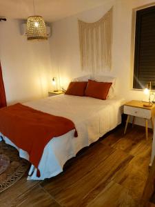 a bedroom with a large white bed with red pillows at Villa de 3 chambres avec vue sur la mer piscine privee et jardin clos a Saint Paul a 1 km de la plage in Saint-Paul