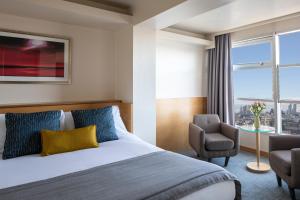 une chambre d'hôtel avec un lit et une chaise dans l'établissement St Giles London – A St Giles Hotel, à Londres