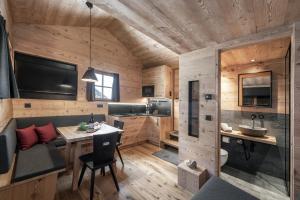 a wooden cabin with a dining room table and a sink at Almhütte Tauber Fane Alm in Valles