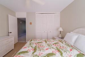 1 Schlafzimmer mit einem Bett mit Blumenbettdecke in der Unterkunft Lilikoi Condo in Kahuku