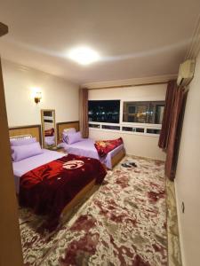 a hotel room with two beds and a window at Nile Riviera in Mansoura in Mansoura