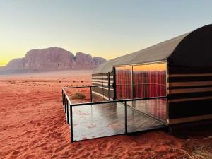 una tenda nel deserto con una montagna sullo sfondo di Bedouin Lifestyle Camp a Wadi Rum