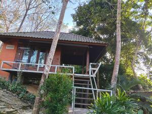 ein kleines Haus mit einer Treppe, die hinauf führt in der Unterkunft ภูริรักษ์ โฮมสเตย์ in Ban Pha Saeng Lang