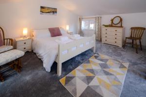 a bedroom with a large white bed and a chair at Juniper HAYLOFT, Grasmere in Ambleside
