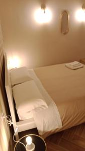 ein Schlafzimmer mit einem Bett und einem Tisch mit einer Lampe in der Unterkunft La Villetta B&B in Reggio di Calabria