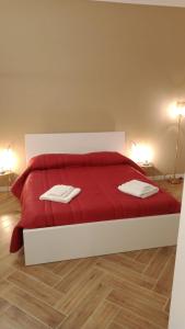 ein Schlafzimmer mit einem roten Bett mit zwei Handtüchern darauf in der Unterkunft La Villetta B&B in Reggio di Calabria