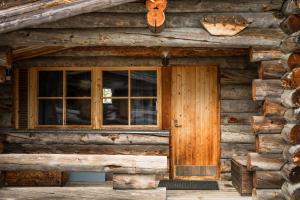 an entrance to a log cabin with a window at Lapland Hotels Äkäshotelli in Äkäslompolo