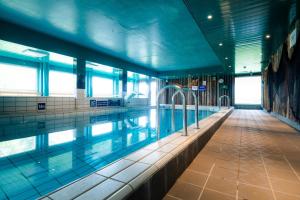 a swimming pool in a building with the water in it at Lapland Hotels Äkäshotelli in Äkäslompolo
