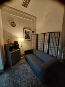 una sala de estar con un sofá azul en una habitación en Pinto Guest Rooms, en Varsovia