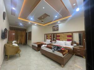 Pokój hotelowy z 2 łóżkami i krzesłem w obiekcie Hotel new royal palace w mieście Lahaur