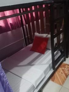 a small bunk bed with a red pillow on it at Lojed Sean bed and space in Manila