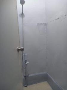 a bathroom with a shower stall with a shower curtain at Lojed Sean bed and space in Manila