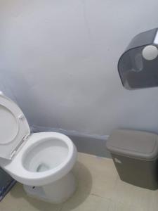 a bathroom with a white toilet in a room at Lojed Sean bed and space in Manila