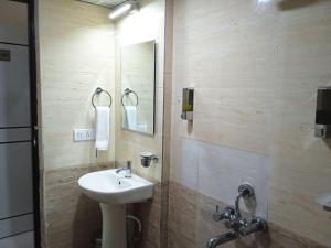 een badkamer met een wastafel en een spiegel bij Tranquil-Homes Ishwerya Suites in Bangalore