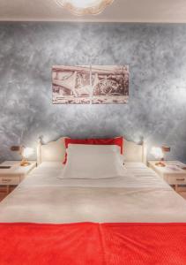 1 dormitorio con 1 cama blanca grande con sábanas rojas en B&B Arcobaleno, en Potenza
