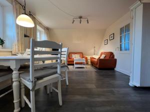 ein Wohnzimmer mit einem Tisch und einem Stuhl in der Unterkunft Greggersen - Whg 1 in Nieblum