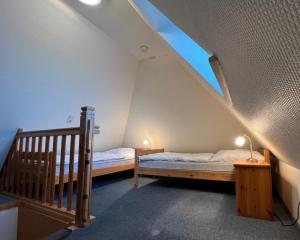 ein Schlafzimmer im Dachgeschoss mit 2 Betten und einer Treppe in der Unterkunft Greggersen - Whg 1 in Nieblum
