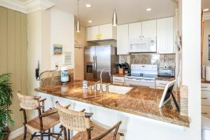 Una cocina con gabinetes blancos y encimera. en D11 - Beachfront Luxury, en Oceanside