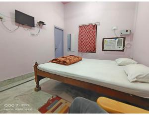 Un pat sau paturi într-o cameră la Jarasandh Lodge, Sasaram