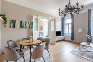 ein Wohnzimmer mit einem Tisch und Stühlen sowie ein Schlafzimmer in der Unterkunft Luxury Elizabeth Residence next to the New York Café in Budapest