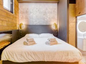 sypialnia z dużym białym łóżkiem i 2 ręcznikami w obiekcie LOVE IN LA CIOTAT w mieście La Ciotat