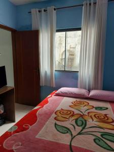 Un dormitorio con una cama grande con un diseño floral. en Abner Residencial, en Florianópolis