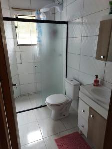 y baño con ducha, aseo y lavamanos. en Abner Residencial, en Florianópolis