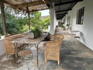 eine Terrasse mit einem Holztisch und Stühlen in der Unterkunft Cornellskop Country Stay in Botrivier