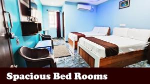 twee bedden in een kamer met blauwe muren bij Hotel MG INN Kanipakam in Kanipakam