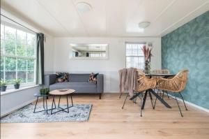 ein Wohnzimmer mit einem Sofa und einem Tisch in der Unterkunft Valkenbosch - De Pimpel 12 in Oisterwijk