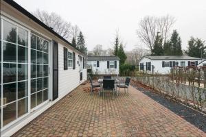 a patio with a table and chairs next to a house at Valkenbosch - De Pimpel 12 in Oisterwijk