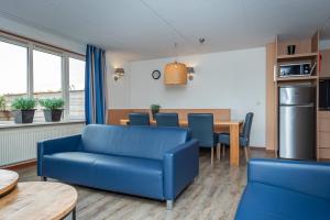 een woonkamer met een blauwe bank en een tafel bij Veluwe Strandbad Elburg in Elburg