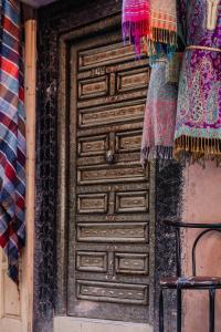 una vieja puerta de madera en un edificio con una bufanda en RIAD BORJ JAMAA LAFNA en Marrakech