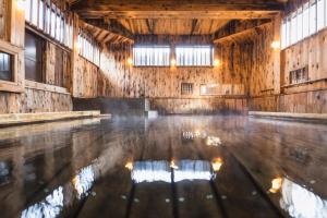 an empty barn with a pool of water in the floor at Tsuta Onsen Ryokan in Towada