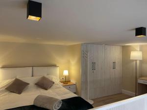 1 dormitorio con 1 cama blanca grande y armario en Lovely apartment in Pogradec city with a lake view, en Pogradec