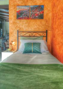 a bedroom with a large bed with a green blanket at B&B Arcobaleno in Potenza