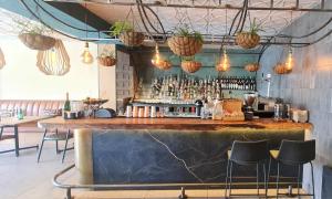 a bar in a restaurant with a counter and chairs at MINT Hotel 84 on Katherine in Johannesburg