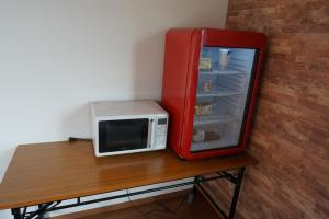 a microwave sitting on a table next to a refrigerator at Guest House Ihatov - Vacation STAY 22102v in Takamatsu
