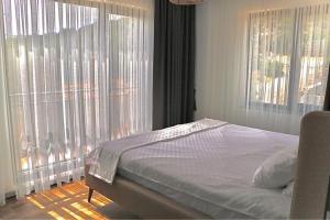 a bedroom with a bed and a large window at Assos Luna Houses in Ayvacık