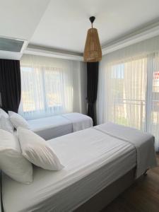 1 dormitorio con 2 camas y luz colgante en Assos Luna Houses, en Ayvacık