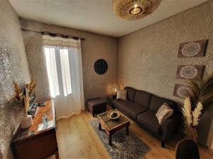 a living room with a couch and a table at GARDENHILL familly 2 chambres in Argelès-Gazost