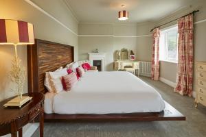a bedroom with a large white bed and a table at Host & Stay - The Old Post Office in Burnsall
