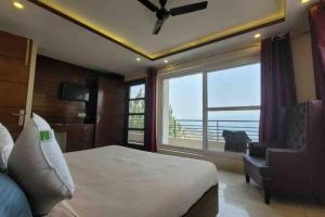 1 dormitorio con cama y ventana grande en PINE PEAK KASAULI en Kasauli