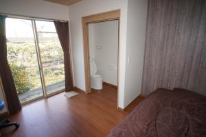 1 dormitorio con 1 cama y puerta al baño en Guest House Ihatov - Vacation STAY 22122v, en Takamatsu