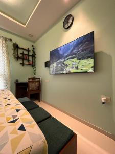 a bedroom with a tv hanging on the wall at Studio Apt with Rooftop Panoramic views @ Dabolim in Vasco Da Gama
