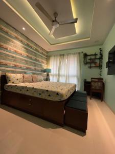 a bedroom with a large bed with a wooden wall at Studio Apt with Rooftop Panoramic views @ Dabolim in Vasco Da Gama
