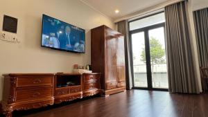 a living room with a flat screen tv on the wall at THANH BÌNH HOTEL, Bình Long in Binh Long