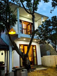 a house with a tree in front of it at Light house beach home in Matara