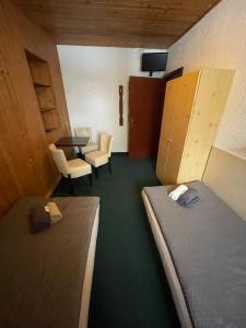 Zimmer mit 2 Betten, einem Tisch und Stühlen in der Unterkunft Penzion Erika in Boží Dar