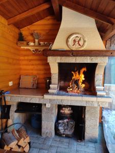 una chimenea de piedra en una cabaña de madera en Villa Boro, en Beli Iskar